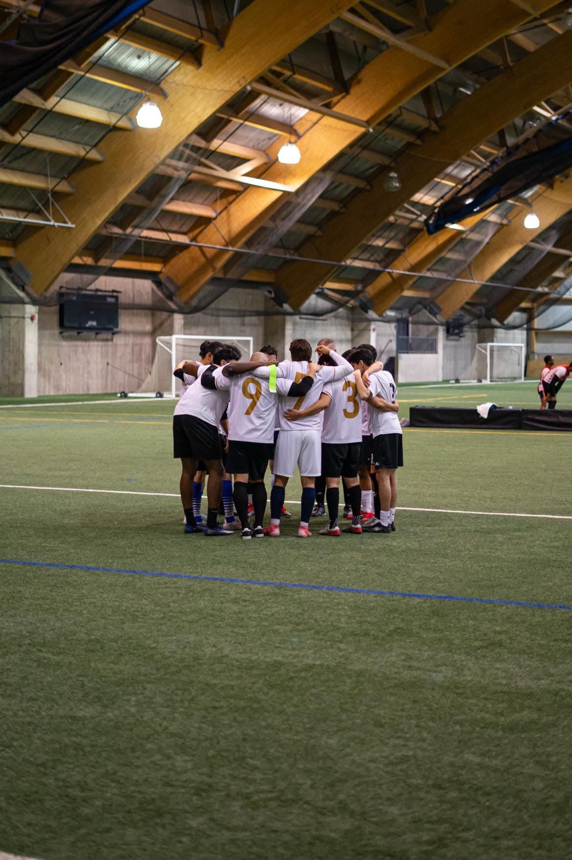 Équipe en cercle au centre du terrain avant le match