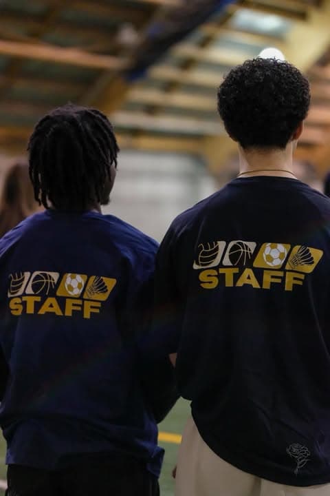 Deux impliqués de dos, vêtus du chandail STAFF de la ligue